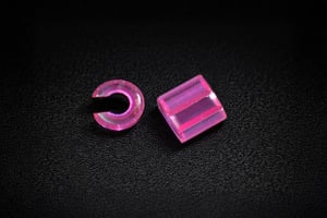 Pink sapphire micro components with curved and prismatic shapes, highlighting miniature custom sapphire parts.