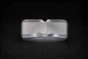 Frosted cylindrical sapphire component with fine surface finish, illustrating a custom sapphire part in macro view.