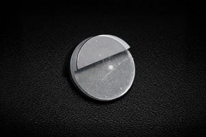 Flat sapphire disc with a precision-cut notch, displayed as a custom sapphire part for technical applications.
