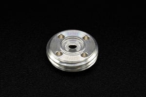 Precision-machined circular metal housing with central opening, designed to integrate a custom sapphire part for high-accuracy applications.