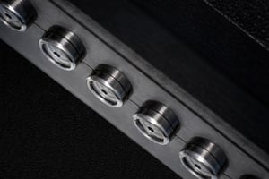 Series of small cylindrical metal mounts aligned on a plate, each engineered to hold a custom sapphire part.