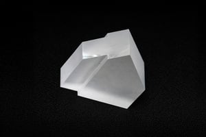 Stepped sapphire block with frosted and polished surfaces, illustrating a precision-machined custom sapphire part.